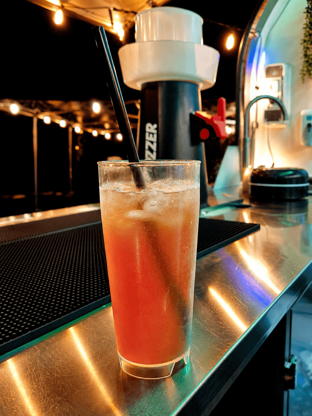 Grün beleuchtete mobile Cocktailbar bei Nacht